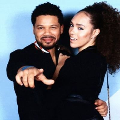 Both are dressed black while Jake is holding her and pointing to the camera.